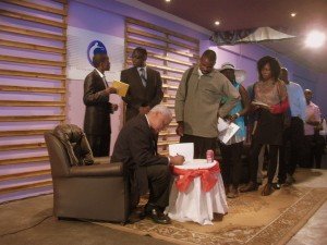 Ambassador Charles Ray signs his book for RelZim.org volunteer Mandla Tshuma